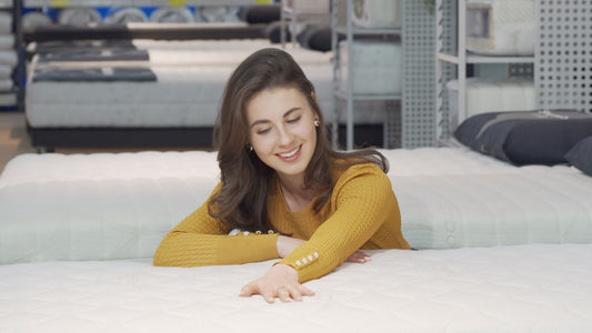Woman testing mattresses in a local mattress store before buying