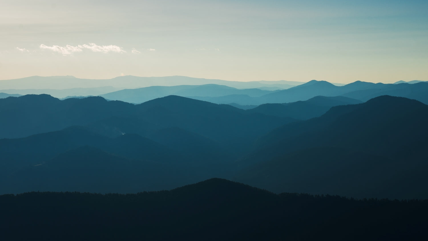 looking far into the mountains in the early morning in a blue sky.