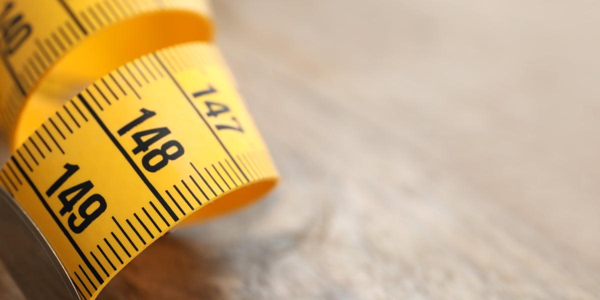 new yellow measuring tape on a wooden table