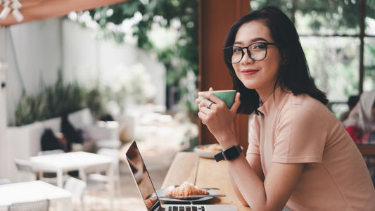 Young asian woman drinking coffee latte with the laptop at the cafe