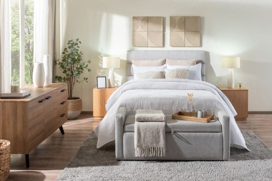 A brightly lit bedroom featuring a bed, full latex mattress, stool, and dressers.