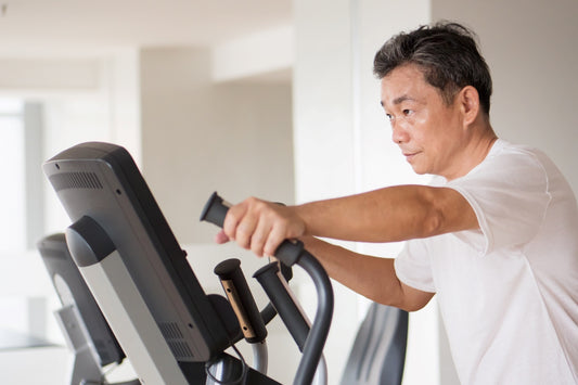 Middle aged man exercise in the gym with cross trainer equipment