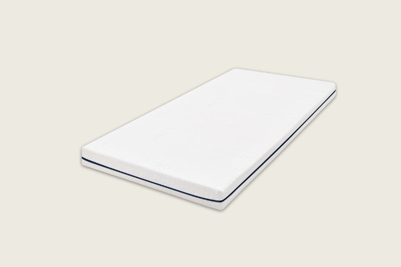 The Good Knight Inoa Mattress made from all-natural latex in its classic white simple mattress design. The mattress is displayed from an angle and shows off its clean minimalistic design. 