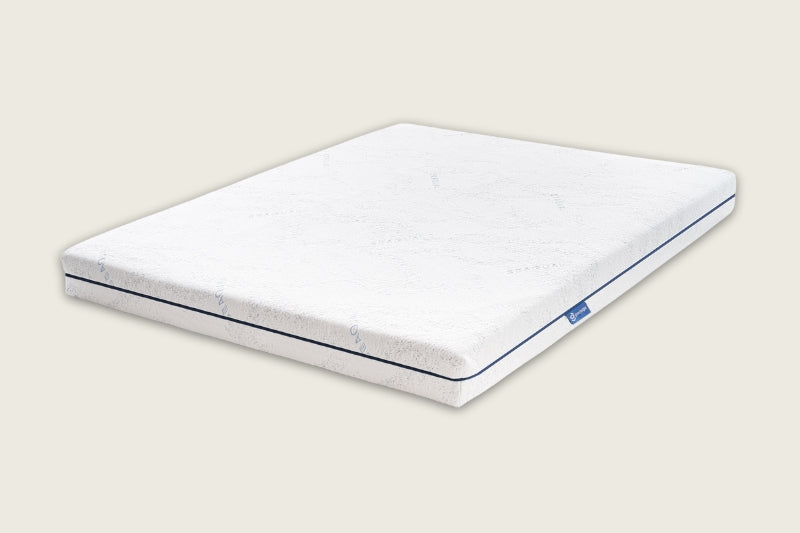 The Good Knight Athena Mattress made from all-natural latex in its signature minimalistic design displayed from an angle and showing its trademark Good Knight logo on a label sewn onto the right side of the mattress. 